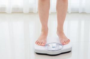 woman on scales, 7 ways to lose weight, by healthista