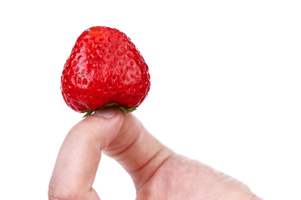 Hand holding a strawberry.