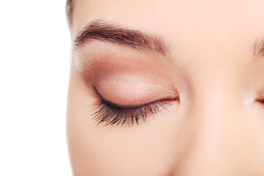 Close up on female's face- eye. Isolated on white.