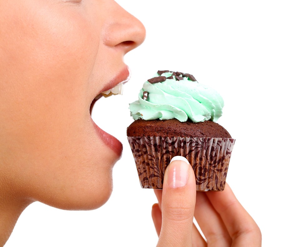 Closeup of woman eating chocolate cupcake