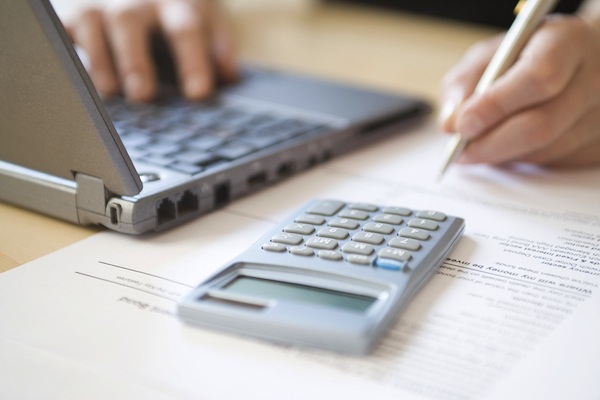 Cropped image of woman's hands calculating home finances at desk