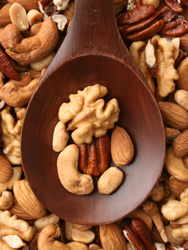 Nuts on a spoon,hree Stress Relief Foods to Have on Hand, by Healthista.com