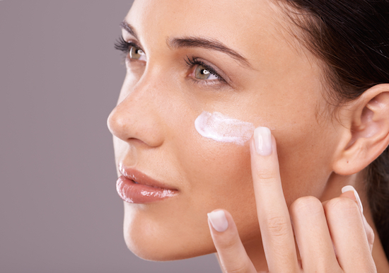 Woman applying moisturiser should you wear sunscreen during winter by Healthist.com