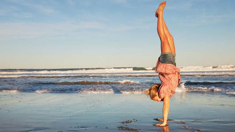 Woman doing handstand at the beach, Expert tip of the week with Genny Wilkinson-Priest, by Healthista.com