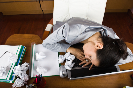 Woman sleeping on desk, How to beat low energy levels and avoid the afternoon slump, by Healthista.com