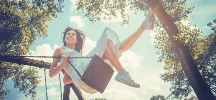 Happy young woman having fun on the swing, by Healthista.com