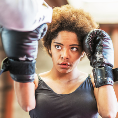 woman hitting mitts, best boxing gear for women by healthista.com