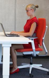 woman in office chair whats really causing your lower back pain by Healthista.com