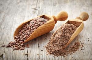 whole and crushed flax seeds on old wooden table