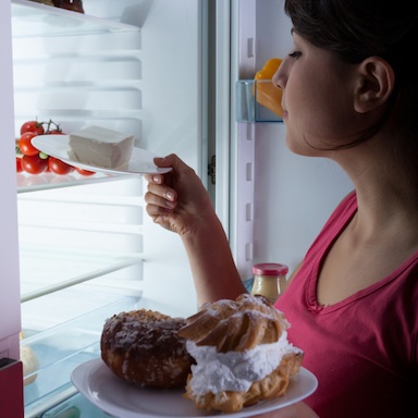 woman eating unhealthy food, is your kitchen making you fat, by healthista.com