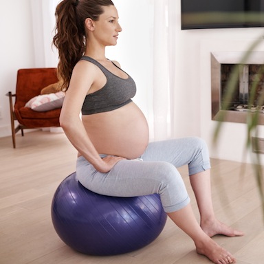 Pregnant women sitting on yoga ball, by healthista