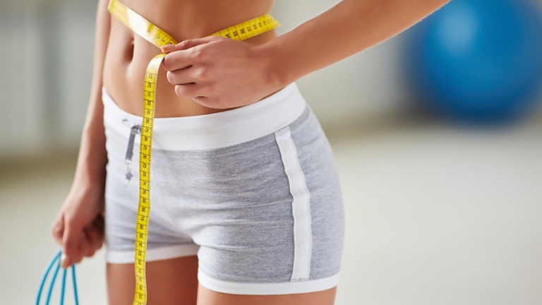 woman measuring her waist, 7 ways to lose weight, by healthista