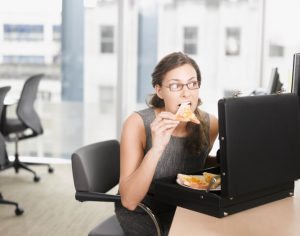 Businesswoman eating pizza from briefcase