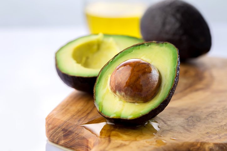 ripe avocado cut in half on white background