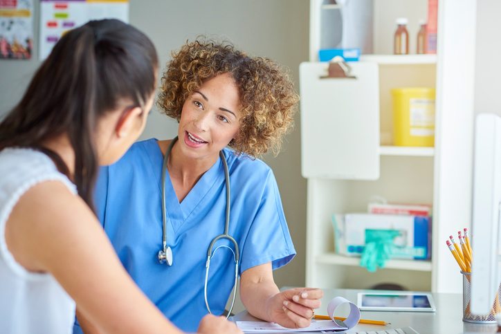 female nurse happily chatting to patient .