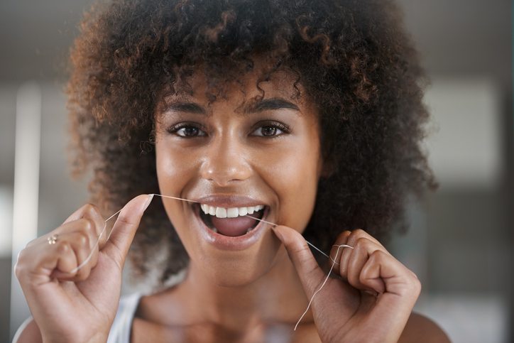 woman flossing 6 things your dentist wishes you would do Healthista