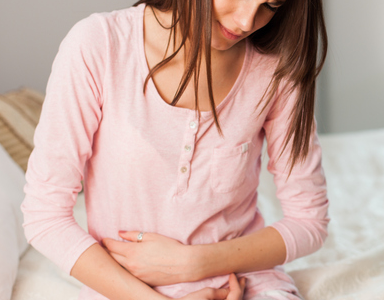 painful woman, symptoms of coeliac disease by healthista.com