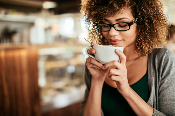 woman happy with coffee, 5 pitfalls of coffee by healthista