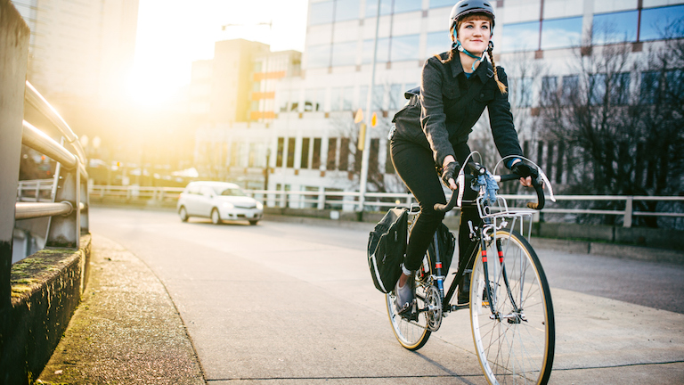 woman-riding-bike-past-building-cycle-plan-made-easy-by-healthista.com-main.jpg