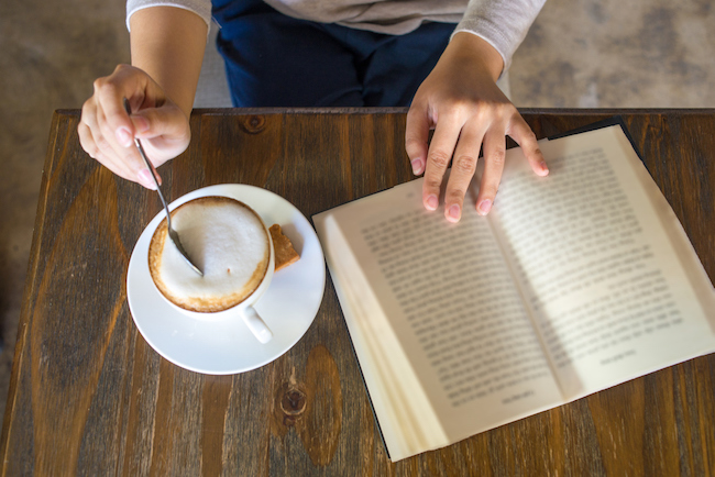 woman-stirring-coffee-reading-book-novels-that-changed-your-life-healthista-body-image.jpg