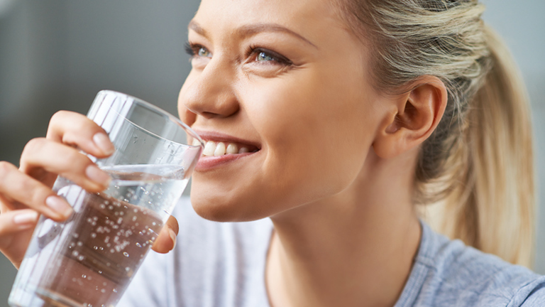 woman drinking water, 'It burns when I pee, what now? The GP's guide by healthista.com