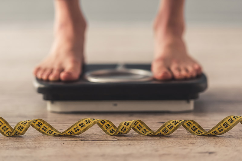 feet-on-scale-with-tape-in-front-12-best-weight-loss-tips-this-nutritionist-has-heard-healthista