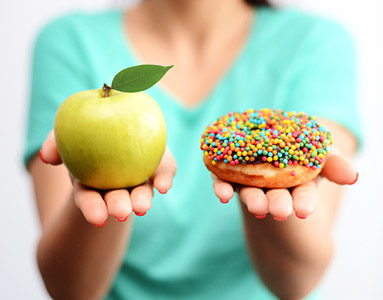 woman-holding-out-an-apple-and-doughnut-12-best-weight-loss-tips-this-nutritionist-has-heard-healthista