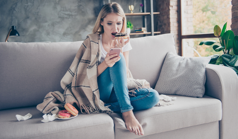 woman eating donuts looking at phone, breakup advice, healthista.com.jpg