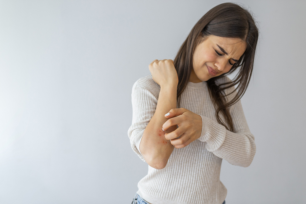 4-ways-stress-is-showing-on-your-skin-and-exactly-how-to-cope-girl-scratching-arm-psoriasis.jpg