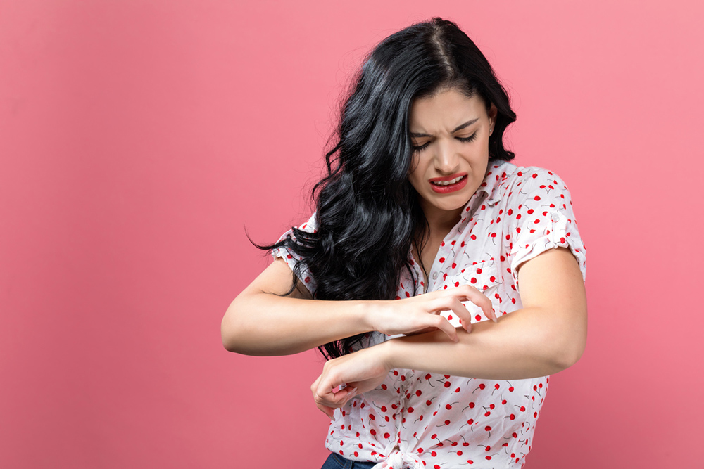 4-ways-stress-is-showing-on-your-skin-and-exactly-how-to-cope-girl-scratching-arm.jpg