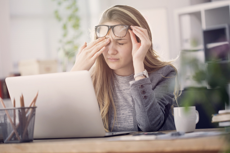 Tired-woman-at-desk-causes-of-tiredness-healthista