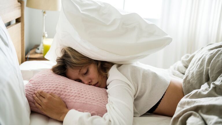 Woman sleeping causes of tiredness main featured healthista