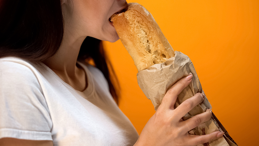 woman-eating-baguette-are-carbs-the-enemy.jpg