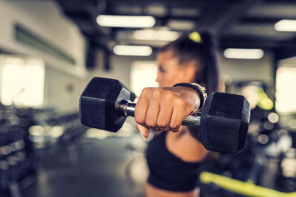 Avoid gym injury woman in gym lifting weights