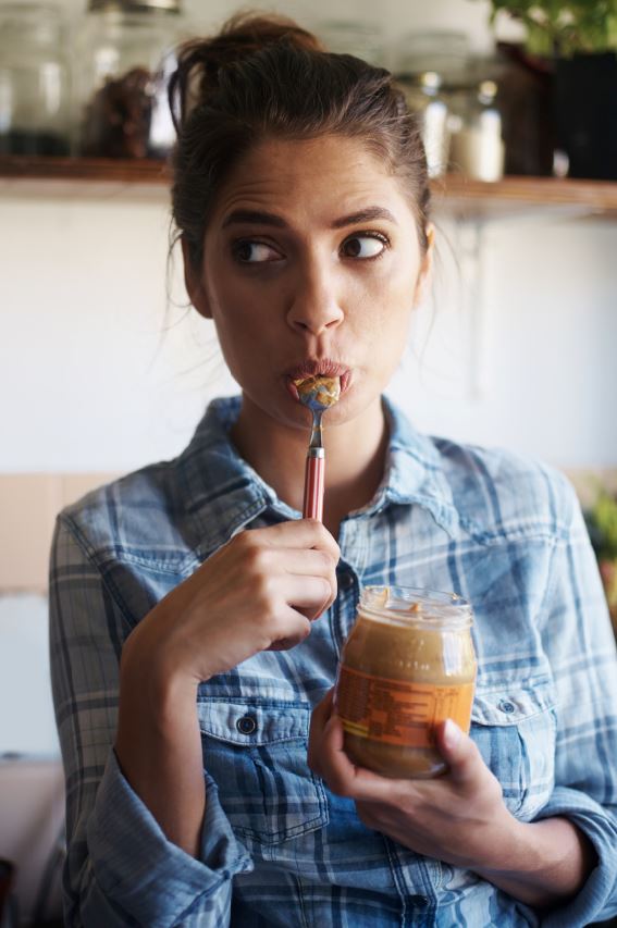 Woman snacking on peanut butter