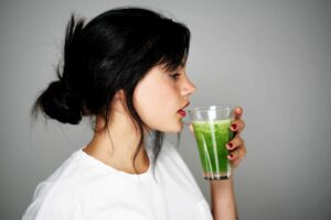 5 ways to detox your body naturally this summer woman drinking green detox juice