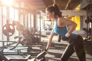 6 strength training benefits everyone should know about woman lifting weights at gym