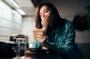 Tired of being tired all the time 7 tried and tested ways to improve your snooze woman eating sandwich at night