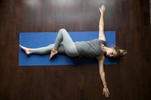 7 Osteopath recommended morning stretches to set you up for the day woman twisting spine on floor