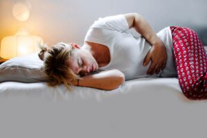 Endometriosis symptoms Here's what you need to know women laying in bed with stomach pain