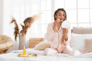 woman applying skincare in bed dry skin