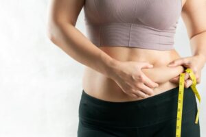 woman measuring waist healthy fats