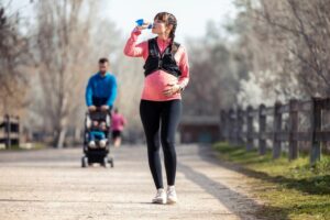 pregnancy exercise woman on walk drinking water