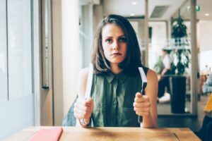 woman feeling hangry at resturant