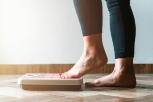 101 ON CALORIE BURNING woman stepping on scales