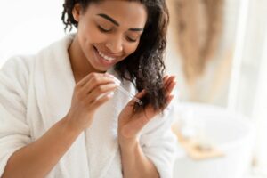 Woman applying hair serum anit ageing haircare