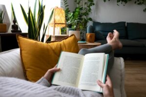 flu season self care woman on sofa reading