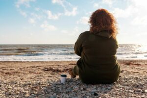 positive mindset mental health woman sat on beach