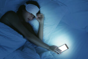 woman-on-phone-in-bed-avoid-social-media-scrolling-at-night.jpg 