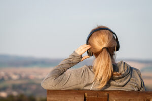 Woman-outdoors-listening-to-music-to-manage-anxiety-symptoms.jpg 